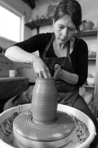 Ceramicist Kirsty Adams at her wheel by photographer Michael Lawler